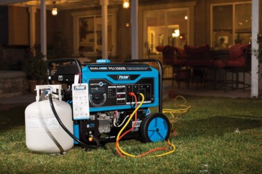 Generator next to small propane tank outside in evening.